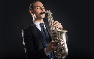 A man in a suit playing the saxophone with passion