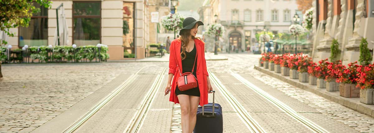 A young woman pulling a suitcase along the street