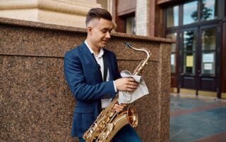 A man in a suit cleaning a saxophone