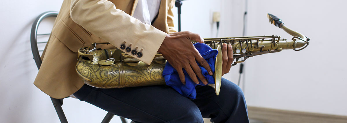 Male hands cleaning the saxophone with a cloth