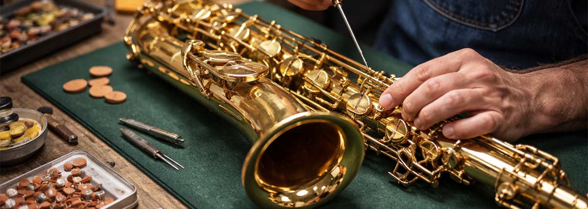 Male hands repairing a saxophone